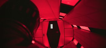 Movie still from “2001: A Space Odyssey” (1968), directed by Stanley Kubrick – Looking down at a room with red lighting and a door; Wide shot, Overhead angle