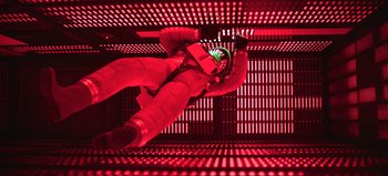 Movie still from “2001: A Space Odyssey” (1968), directed by Stanley Kubrick – A person in a spacesuit in a room with red lights; Wide shot, Overhead angle