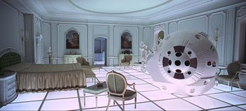 Movie still from “2001: A Space Odyssey” (1968), directed by Stanley Kubrick – A living room filled with furniture next to a wall with paintings; Extreme Wide shot, High angle