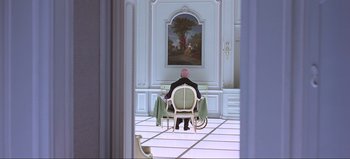 Movie still from “2001: A Space Odyssey” (1968), directed by Stanley Kubrick – A man sitting in a chair in front of a painting; Wide shot, High angle
