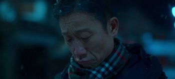 Movie still from “20th Century Girl” (2022), directed by Woo-ri Bang – A man with a scarf on his head is looking down; Close Up shot, Low angle