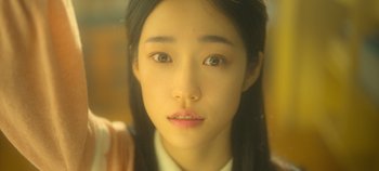 Movie still from “20th Century Girl” (2022), directed by Woo-ri Bang – A young asian woman's face; Extreme Close Up shot, High angle