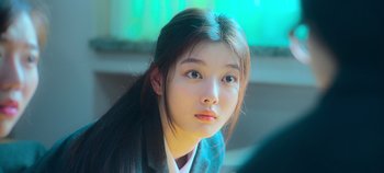 Movie still from “20th Century Girl” (2022), directed by Woo-ri Bang – A young woman with long black hair looking at the camera; Close Up shot, Over the shoulder angle