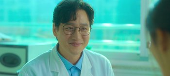 Movie still from “20th Century Girl” (2022), directed by Woo-ri Bang – A man in a white lab coat and glasses; Close Up shot, Over the shoulder angle