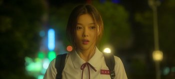 Movie still from “20th Century Girl” (2022), directed by Woo-ri Bang – A young woman wearing a white shirt and a red bow tie; Close Up shot, Over the shoulder angle