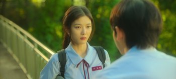 Movie still from “20th Century Girl” (2022), directed by Woo-ri Bang – A young woman wearing a white shirt and a red tie; Close Up shot, Over the shoulder angle