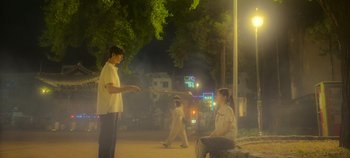 Movie still from “20th Century Girl” (2022), directed by Woo-ri Bang – A couple of people that are playing baseball on the street; Wide shot, Low angle