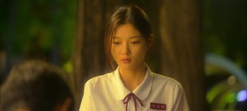 Movie still from “20th Century Girl” (2022), directed by Woo-ri Bang – A young woman in a white shirt and red tie; Close Up shot, Over the shoulder angle