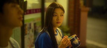 Movie still from “20th Century Girl” (2022), directed by Woo-ri Bang – A woman holding a can of ice cream in her hands; Medium shot, Over the shoulder angle
