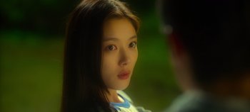 Movie still from “20th Century Girl” (2022), directed by Woo-ri Bang – A young woman with long dark brown hair and pink eyes; Close Up shot, Over the shoulder angle