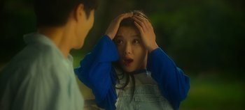 Movie still from “20th Century Girl” (2022), directed by Woo-ri Bang – A young girl holding her hands up to her head; Close Up shot, Over the shoulder angle