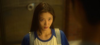 Movie still from “20th Century Girl” (2022), directed by Woo-ri Bang – A young woman with long black hair wearing a white and blue shirt; Close Up shot, Low angle