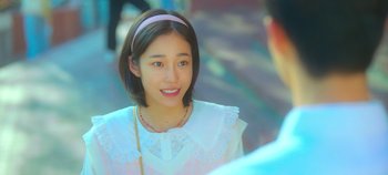 Movie still from “20th Century Girl” (2022), directed by Woo-ri Bang – A young woman wearing a white shirt and a pink headband; Close Up shot, Over the shoulder angle