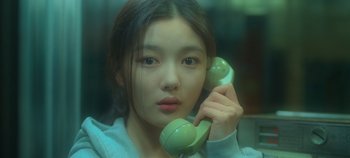 Movie still from “20th Century Girl” (2022), directed by Woo-ri Bang – A young woman holding a phone up to her ear; Close Up shot, High angle