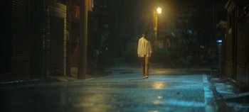 Movie still from “20th Century Girl” (2022), directed by Woo-ri Bang – A man walking down a street at night; Wide shot, Low angle