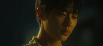 Movie still from “20th Century Girl” (2022), directed by Woo-ri Bang – A young man's face in the dark; Close Up shot, Low angle