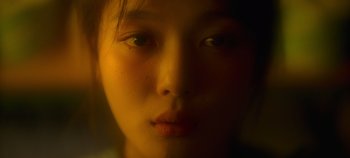 Movie still from “20th Century Girl” (2022), directed by Woo-ri Bang – A young woman's face in a dimly - lit room; Extreme Close Up shot, Over the shoulder angle