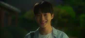Movie still from “20th Century Girl” (2022), directed by Woo-ri Bang – A young man smiles for the camera; Close Up shot, Over the shoulder angle