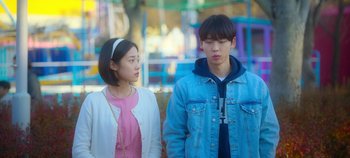 Movie still from “20th Century Girl” (2022), directed by Woo-ri Bang – A young man and a young woman standing next to each other; Medium shot, Over the shoulder angle