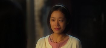 Movie still from “20th Century Girl” (2022), directed by Woo-ri Bang – A woman with short black hair wearing a pink shirt; Close Up shot, Over the shoulder angle