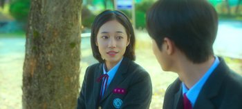 Movie still from “20th Century Girl” (2022), directed by Woo-ri Bang – A young girl in a school uniform talking to a young man; Close Up shot, Over the shoulder angle