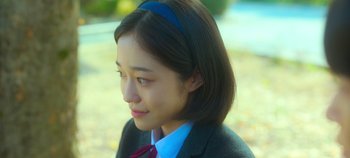 Movie still from “20th Century Girl” (2022), directed by Woo-ri Bang – A woman with a blue headband is looking to the side; Close Up shot, Over the shoulder angle