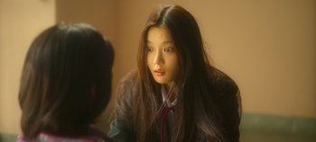 Movie still from “20th Century Girl” (2022), directed by Woo-ri Bang – A young woman sitting in front of a mirror; Close Up shot, Over the shoulder angle