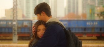 Movie still from “20th Century Girl” (2022), directed by Woo-ri Bang – A man and a woman embracing each other; Medium shot, Low angle