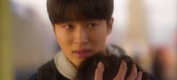 Movie still from “20th Century Girl” (2022), directed by Woo-ri Bang – A young man holding a baby in his arms; Extreme Close Up shot, Over the shoulder angle