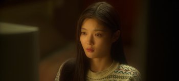Movie still from “20th Century Girl” (2022), directed by Woo-ri Bang – A woman with long black hair wearing a white sweater; Close Up shot, High angle