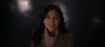 Movie still from “20th Century Girl” (2022), directed by Woo-ri Bang – A woman with long black hair wearing a brown jacket; Close Up shot, High angle