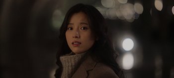 Movie still from “20th Century Girl” (2022), directed by Woo-ri Bang – A woman with long black hair wearing a sweater; Close Up shot, Low angle