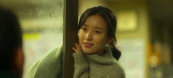 Movie still from “20th Century Girl” (2022), directed by Woo-ri Bang – A young woman leaning against a wall with her hand on her chin; Close Up shot, Over the shoulder angle