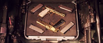 Movie still from “22 Jump Street” (2014), directed by Phil Lord – Two gold plated pistols are in a briefcase; Extreme Close Up shot, High angle