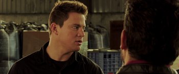 Movie still from “22 Jump Street” (2014), directed by Phil Lord – A man talking to another man in front of a building; Close Up shot, Over the shoulder angle