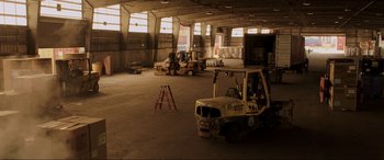 Movie still from “22 Jump Street” (2014), directed by Phil Lord – An empty warehouse with a forklift in the middle of the floor; Extreme Wide shot, High angle