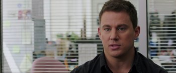 Movie still from “22 Jump Street” (2014), directed by Phil Lord – A person wearing a black shirt near a window; Close Up shot, Over the shoulder angle