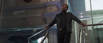 Movie still from “22 Jump Street” (2014), directed by Phil Lord – A man standing on top of a metal railing next to a building; Medium shot, Low angle