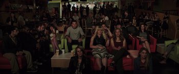 Movie still from “22 Jump Street” (2014), directed by Phil Lord – A group of people sitting on a red couch in a room; Wide shot, High angle