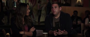 Movie still from “22 Jump Street” (2014), directed by Phil Lord – A man and a woman are sitting at a table; Medium shot, Over the shoulder angle