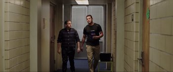 Movie still from “22 Jump Street” (2014), directed by Phil Lord – Two men walking down a hallway in a building; Medium shot, Low angle