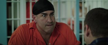 Movie still from “22 Jump Street” (2014), directed by Phil Lord – A man with a black head band is wearing an orange shirt; Close Up shot, Over the shoulder angle