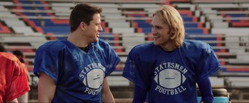 Movie still from “22 Jump Street” (2014), directed by Phil Lord – Two football players talking to each other in a stadium; Medium shot, Over the shoulder angle
