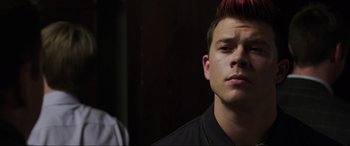 Movie still from “22 Jump Street” (2014), directed by Phil Lord – A young man with a red mohawk is looking at the camera; Close Up shot, Over the shoulder angle