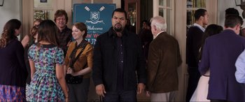 Movie still from “22 Jump Street” (2014), directed by Phil Lord – Two men and a woman standing in front of a building; Medium shot, Over the shoulder angle