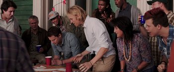 Movie still from “22 Jump Street” (2014), directed by Phil Lord – A group of young people standing around a table; Medium shot, High angle