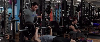 Movie still from “22 Jump Street” (2014), directed by Phil Lord – A man and a woman working out in a gym; Medium shot, Over the shoulder angle