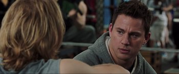 Movie still from “22 Jump Street” (2014), directed by Phil Lord – A man sitting in front of another man in a gym; Close Up shot, Over the shoulder angle