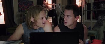 Movie still from “22 Jump Street” (2014), directed by Phil Lord – Two young men sitting in front of a computer screen; Medium shot, Over the shoulder angle