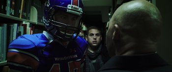 Movie still from “22 Jump Street” (2014), directed by Phil Lord – A group of men standing next to each other in a room; Medium shot, Over the shoulder angle